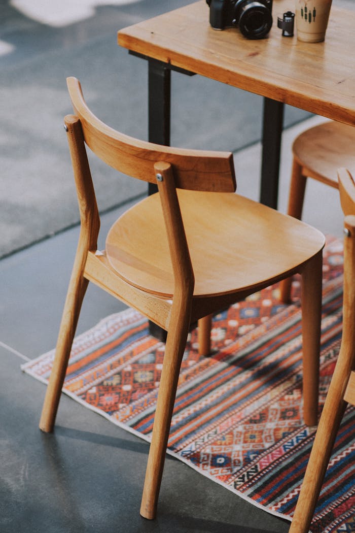 A simple wooden chair on a vibrant carpet adds charm to a modern indoor setting.